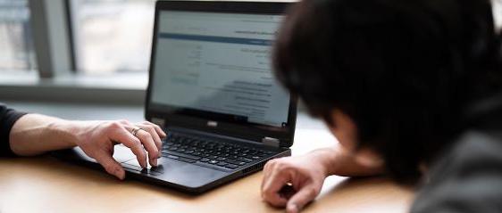 Two students using a laptop together